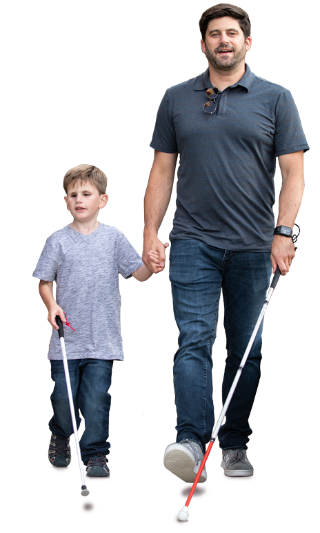 A young boy and man walking while holding hands and both using white canes.
